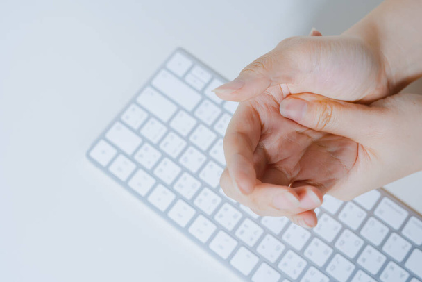 Massage Hand und Finger nach Schmerzen und Schmerzen im Büro arbeiten mit weißen isolierten Hintergrund - Foto, Bild