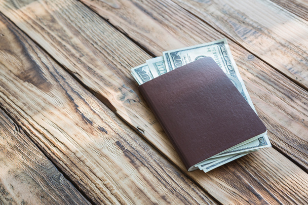 Blank passport with US dollars on wood table - Foto, afbeelding