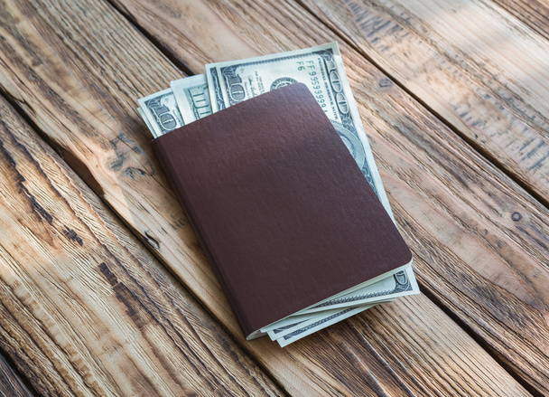 Blank passport with US dollars on wood table - Фото, изображение