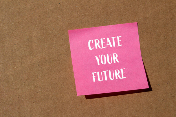 Tworzenie przyszłych słów napisanych na różowym papierze naklejki z brązowym tle. Koncepcja stworzyć swój przyszły symbol. Przestrzeń kopiowania. - Zdjęcie, obraz