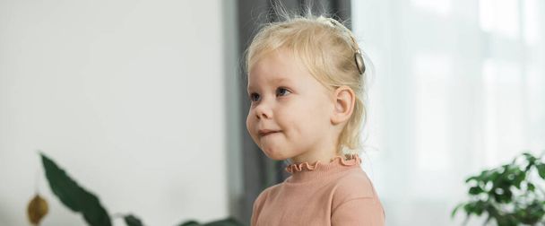 Смешной ребенок с кохлеарным имплантом сидит дома и ест. Услышать помощь и медицина инновационных технологий и разнообразия концепции - Фото, изображение