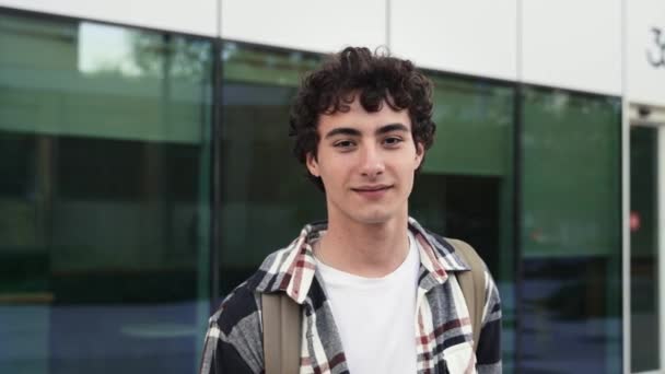 Portret van lachende tiener latino mannelijke student op zoek naar camera  - Video