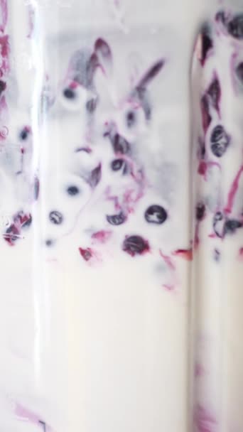 Die Zubereitung eines Frucht-Smoothie oder rosa Milchshake im Mixer Closeup Beeren Früchte fallen lila Smoothie-Mischung im elektrischen Mixer. Erdbeer-Blaubeer-Granatapfel von oben in saftiges Getränk fallen gelassen - Filmmaterial, Video