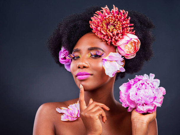 Bloemen, idee en portret van afro zwarte vrouw in studio op donkere achtergrond voor cosmetica of redactioneel. Schoonheid, gezichtsmake-up of denken en jong model met protea in het haar voor esthetische wellness. - Foto, afbeelding