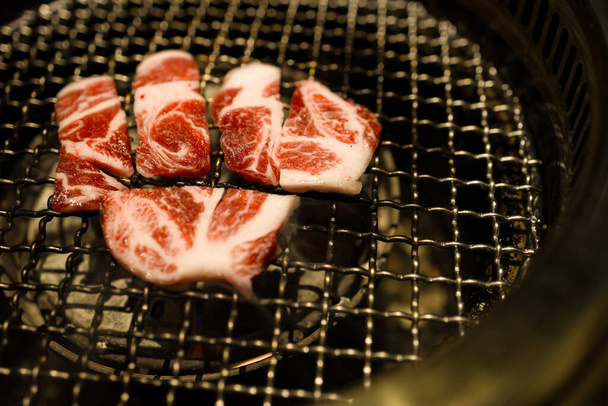  slices of beef being grilled over a charcoal fire - Photo, Image