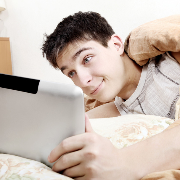 Уставший подросток с планшетным компьютером
 - Фото, изображение