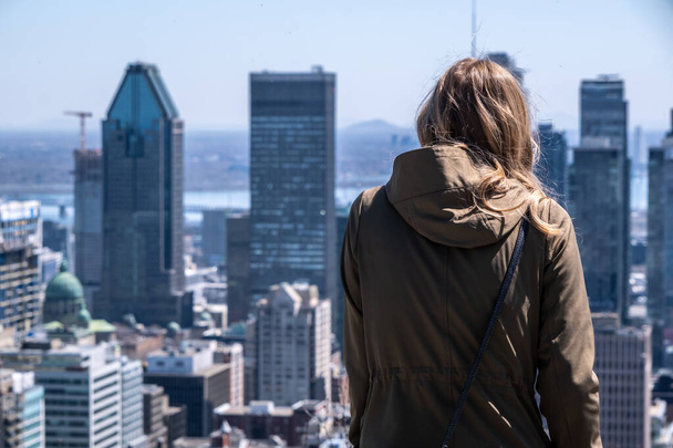 Montreal, CA - 125 Duben 2024: Mladá žena při pohledu na panorama Montrealu a těší teplý jarní den na Kondiaronk Belvedere. - Fotografie, Obrázek