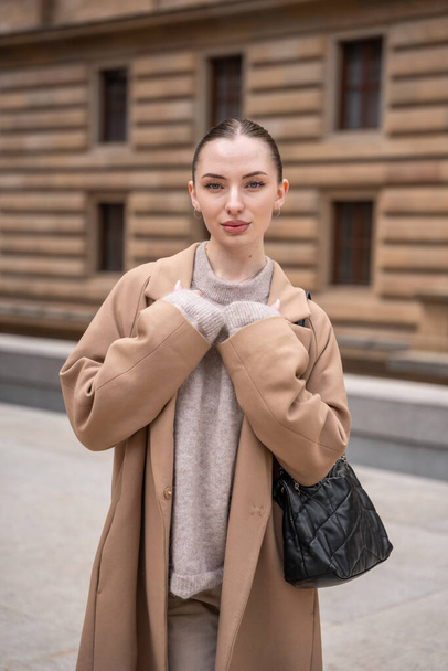 Portrait of young beautiful woman wearing coat walking in the city centre of Prague, Europe. High quality photo - Photo, Image