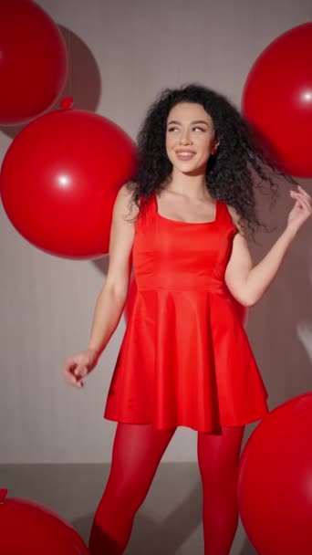 Žena v červených šatech a punčocháče s obrovskými červenými balónky. - Záběry, video