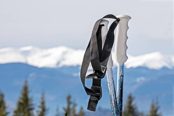 лыжные палки на фоне снежных вершин горнолыжного курорта. Мероприятия и школьные каникулы - Фото, изображение