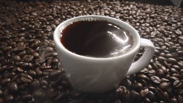 Kahve ya da kahve çekirdekli espresso manzarası. Taze kavrulmuş kahve çekirdeğini yakın çekimde ahşap masanın etrafına bir fincan americano ve aromatik akarsu ve tohum dumanı serpin. Geliştirilebilir. - Fotoğraf, Görsel