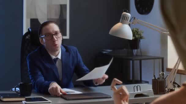 Střední záběr pracovníka mužské kanceláře hledajícího chybějící prezentační stránku na stole, ošklivý kolega držící dokument nahoře, posmívající se mu a škádlící ho - Záběry, video