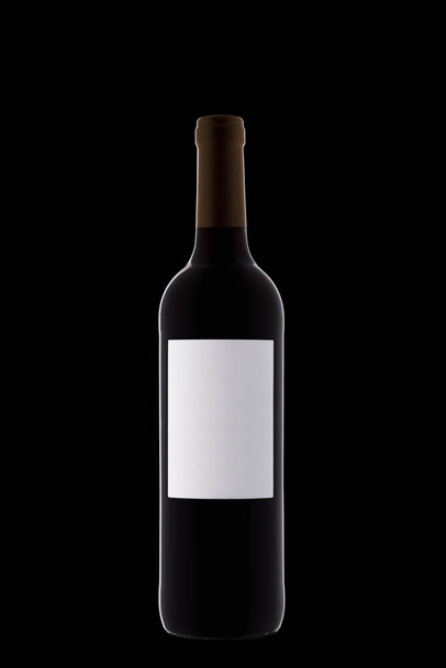 Láhev vína s bílým štítkem s krásnými zvýraznění na černém pozadí close-up - Fotografie, Obrázek