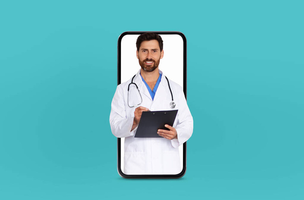 Un médecin mature se tient à l'intérieur d'un écran vide de smartphones, symbolisant une consultation de télémédecine, dans un environnement clinique moderne - Photo, image
