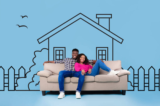 Afro-Américain homme et femme sont assis sur un canapé devant la maison de banlieue dessinée sur fond bleu, couple rêvant de la maison - Photo, image