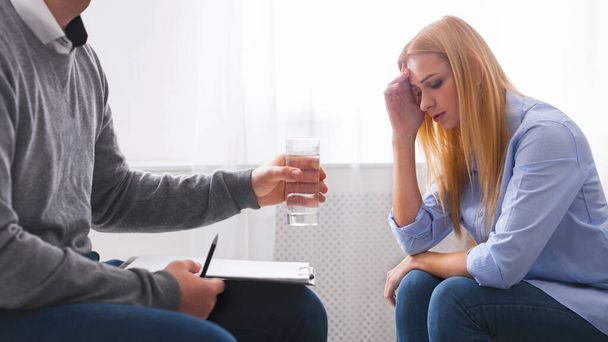 Es wird helfen. Psychotherapeutin bietet weinenden Patientinnen ein Glas Wasser an, Panorama, freier Raum - Foto, Bild