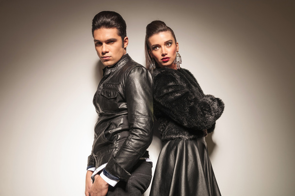 Fashion man and woman standing back to back  - 写真・画像