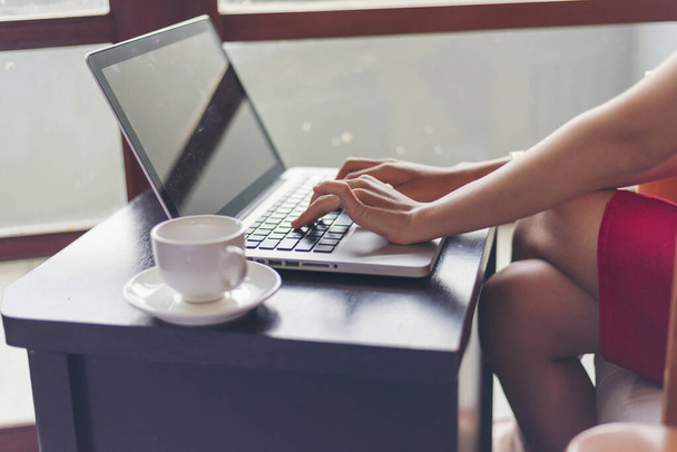 Asian Female freelance using laptop at home office desk. Woman reading financial graph chart Planning analyzing marketing data. Asian female people working office firm with business stuff, coffee cup - Foto, Bild