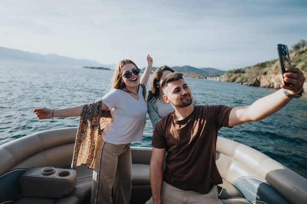 Un gioioso gruppo di amici in gita in barca, scattando selfie e vivendo l'emozione del mare durante un rilassante weekend di vacanza. - Foto, immagini