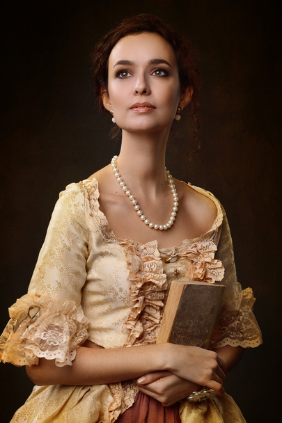 Портрет женщины в историческом платье с книгой в руках
 - Фото, изображение