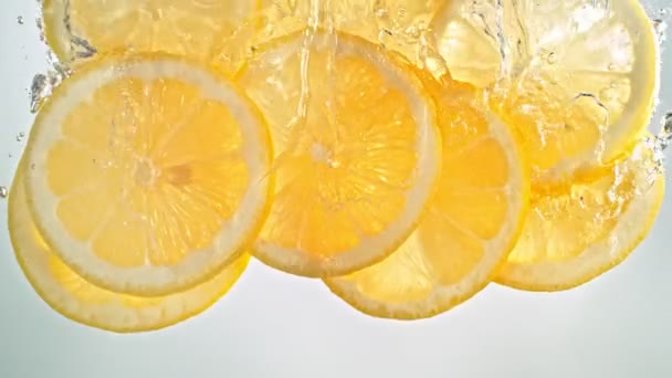 Super Slow Motion Shot of Fresh Lemon szeletek Vízbe hulló és áramló 1000 fps. Nagysebességű mozi kamerával 4K felbontásban. - Felvétel, videó