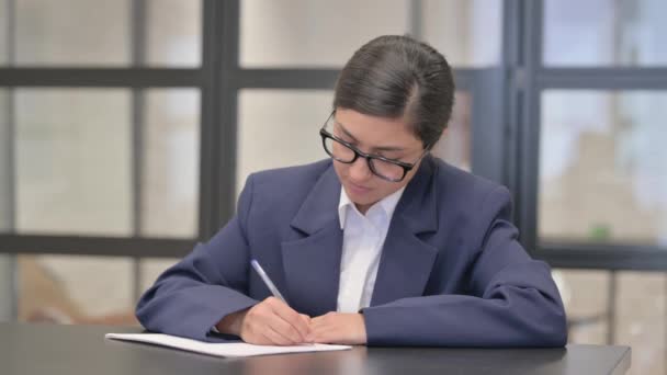 Представительница смешанной расы, пишущая письмо в офисе - Кадры, видео