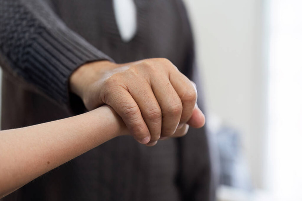 Lekarze lub pielęgniarki trzymają za ręce pacjentów w podeszłym wieku, aby wspierać i łagodzić. - Zdjęcie, obraz