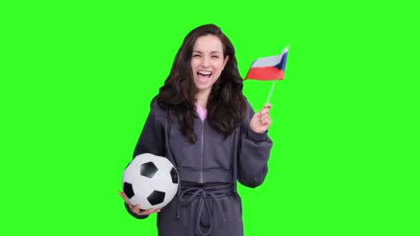 Lachende jonge vrouwelijke fan poseren met de Tsjechische vlag, terwijl het houden van een voetbal, vieren van de overwinning van het team op groen geïsoleerde - Video