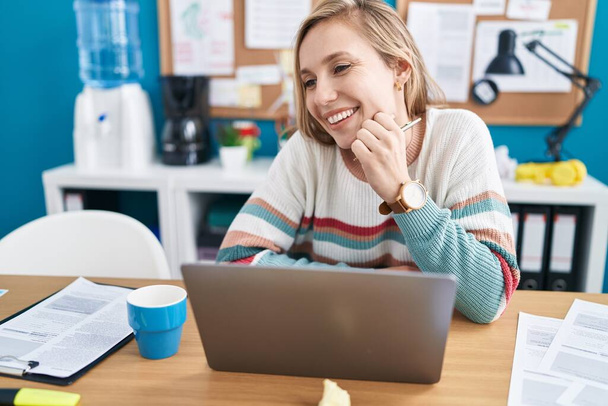 Молода блондинка бізнесмен використовує ноутбук, що працює в офісі
 - Фото, зображення