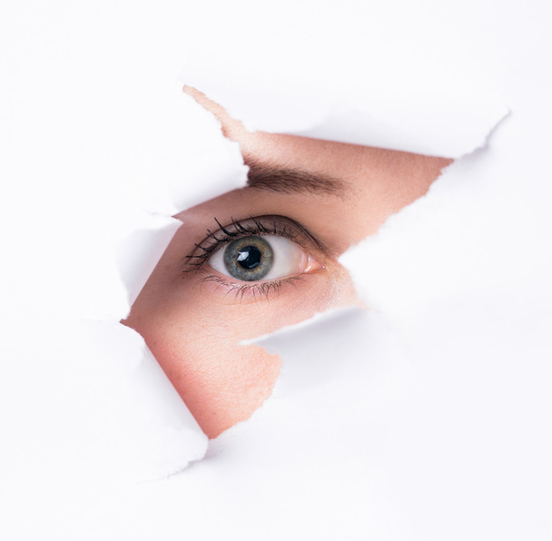 Mujeres ojos a través de un agujero en un papel
 - Foto, Imagen