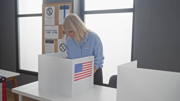 Una joven rubia con camisa a rayas emite su voto en un centro electoral americano, representando la democracia y el deber cívico. - Foto, imagen