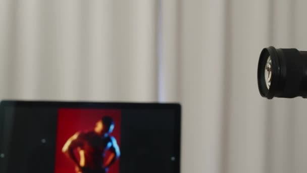 Muž módní fotograf v brýlích střelba pohledný atletický muž s svalnatým tělem pro obálku časopisu ve studiu - Záběry, video