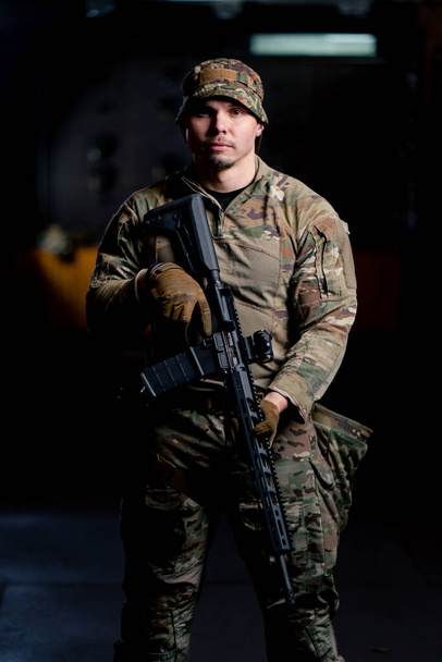 ένα επαγγελματικό πεδίο βολής ένας εκπαιδευτής στρατιωτικών τακτικών στέκεται με ένα τουφέκι του ΝΑΤΟ - Φωτογραφία, εικόνα