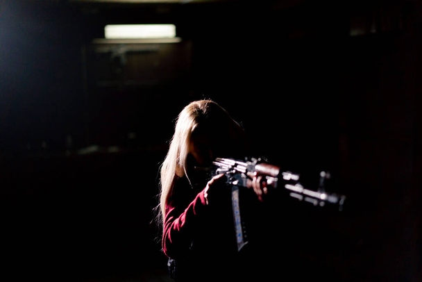 戦術戦略軍の少女は暗いコントラストライトバックライトシルエットを目指すライフルで立っています - 写真・画像