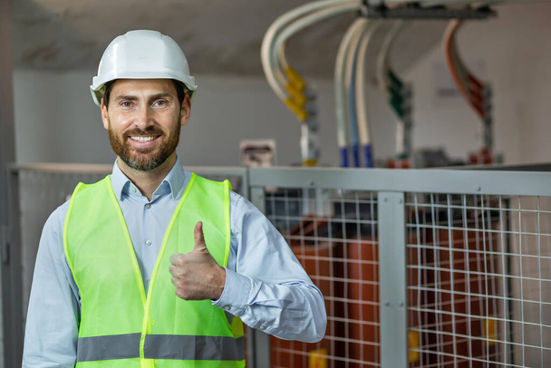 Happy technician contractor mechanic in hardhat helmet showing ok gesture recommend okay sign factory work - Foto, imagen
