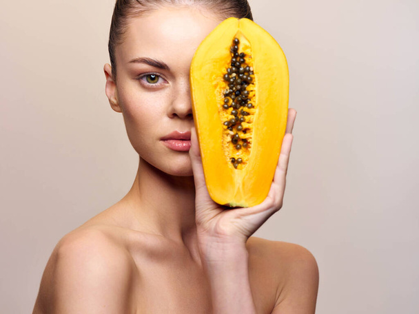 Schöne junge Frau mit Papaya-Frucht-Gesichtsmaske, isoliert auf weißem Hintergrund, Hautpflege und Schönheitskonzept - Foto, Bild