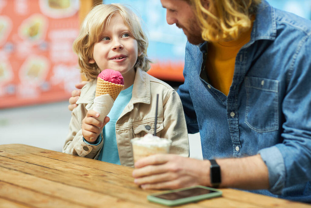 Portrét otce a syna, jak jedí zmrzlinu a užívají si čas sbližování - Fotografie, Obrázek