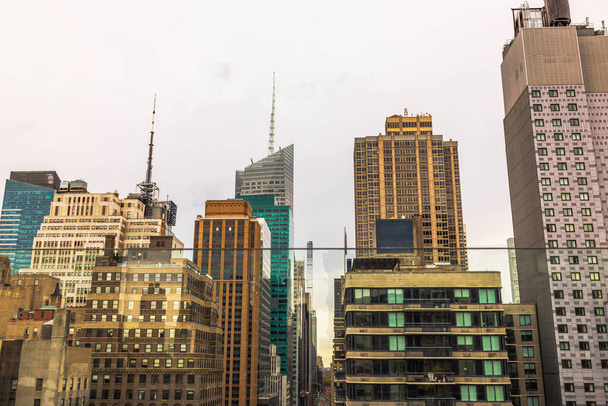 Panoramiczny widok na gęstą panoramę miasta w Nowym Jorku, prezentujący mieszankę nowoczesnych szklanych drapaczy chmur i tradycyjnej architektury pod chmurowym niebem. Nowy Jork.  - Zdjęcie, obraz