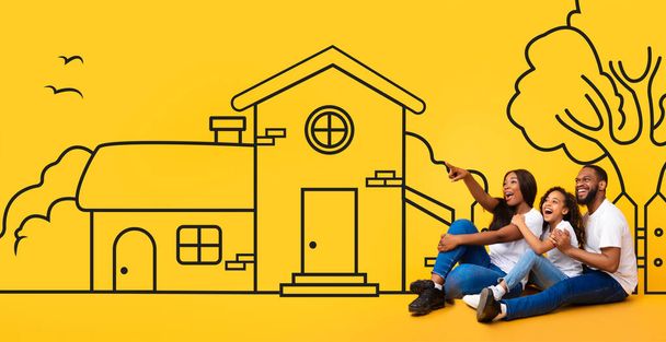 A happy African American family sits closely together against a vibrant yellow backdrop that features a whimsical drawing of a house - Photo, Image