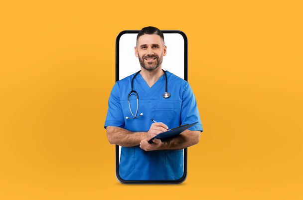 Un professionnel de la santé d'âge moyen apparaît dans un écran de smartphone, s'engageant dans une consultation numérique sur la santé, à l'intérieur d'un bureau bien éclairé - Photo, image