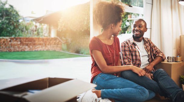 Black couple, real estate and happy on floor of new house with bonding, support and break or relax from moving. People, homeowner or smile for property investment, dream home or relocation with boxes. - Photo, Image