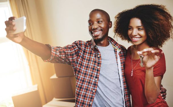 Black couple, real estate or smile with selfie new house with bonding, support and break or relax from moving. People, homeowner or excited for property investment, dream home or relocation with keys. - Photo, Image