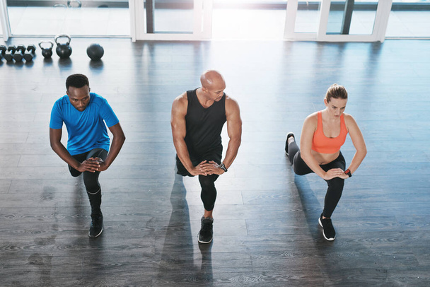 Fitness, edző és tüdő testmozgás tornaterem, sokszínűség vagy az emberek wellness központ edzés és erős láb izmok. Edzés, egészség és támogatás az edzés kihívás, aktív sportolók. - Fotó, kép