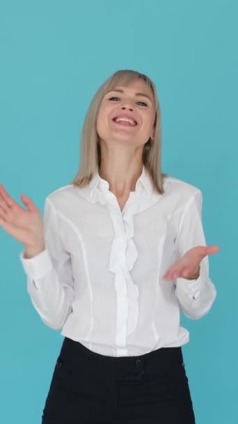Delighted and excited Caucasian businesswoman clapping in appreciation and acceptance on blue background. Celebration success. Vertical video. - Footage, Video