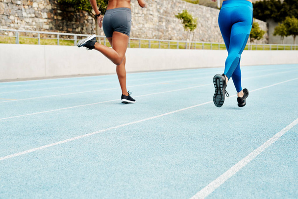 Ihmiset, jalat tai juoksijat radalla liikuntaan, koulutukseen tai ulkoiluun kuntoiluun energialla. Joukkue, selkä tai urheilijat käynnissä stadionilla nopeudella tai liikkeen käytännön, hyvinvointi tai terveys. - Valokuva, kuva