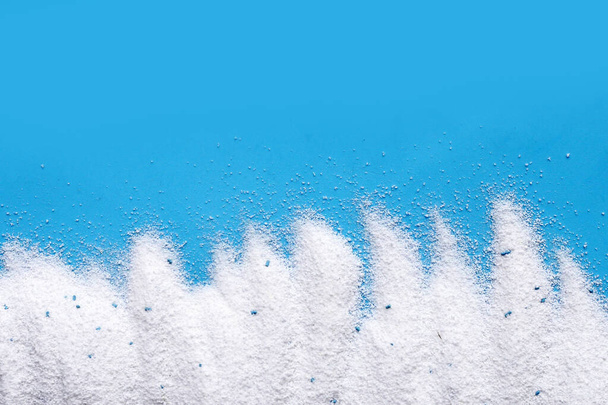 Detergent powder on blue background. Laundry concept. - Foto, afbeelding