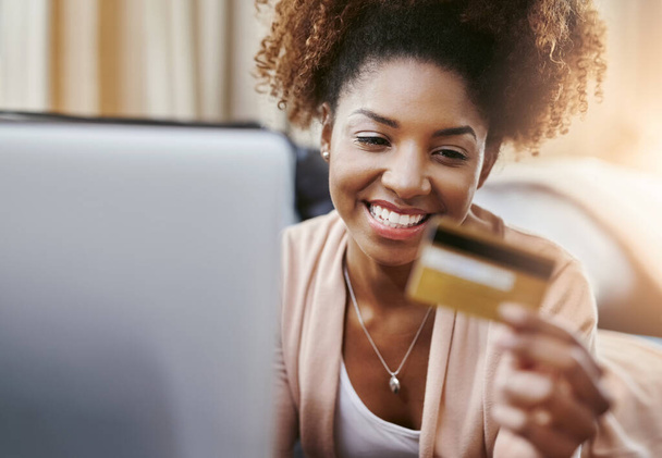 Πιστωτική κάρτα, laptop και χαρούμενη μαύρη γυναίκα στον καναπέ για online αγορές, αγορά στο διαδίκτυο και πληρωμή. Ηλεκτρονικό εμπόριο, fintech και πρόσωπο στον υπολογιστή για την αγορά ιστοσελίδα, τις πωλήσεις και την ψηφιακή τραπεζική στο σπίτι. - Φωτογραφία, εικόνα