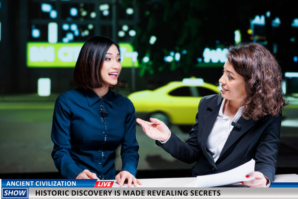 Show hosts reveal historic discovery made by specialists and experts, finding ancient civilization remains. Newscasters team debating historical disclosure on international tv program. - Photo, Image
