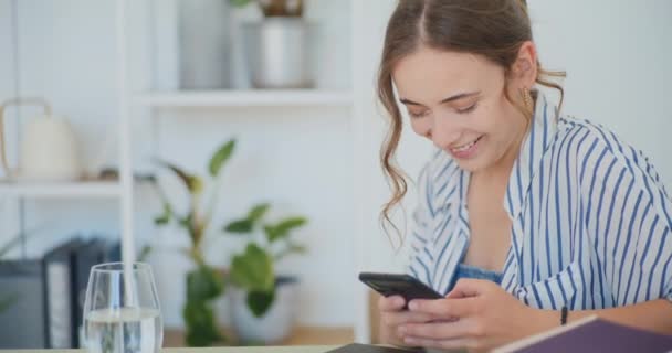Vrouw comfortabel sms 'en op smartphone terwijl ze op de bank zit - Video