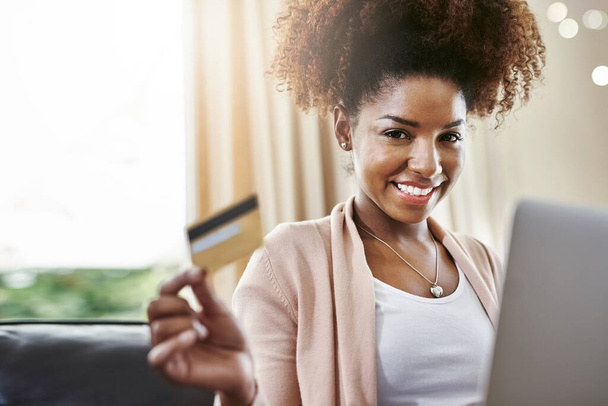 Πιστωτική κάρτα, φορητό υπολογιστή και πορτρέτο της μαύρης γυναίκας στον καναπέ στο σπίτι για online αγορές, αγορά στο διαδίκτυο και πληρωμή. Ηλεκτρονικό εμπόριο, fintech και πρόσωπο στον υπολογιστή για την ιστοσελίδα, τις πωλήσεις και την ψηφιακή τραπεζική. - Φωτογραφία, εικόνα